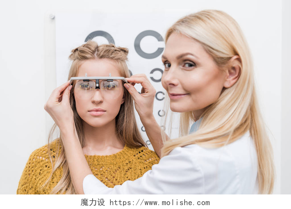 在为女人佩戴测试工具的医生女性病人和眼镜师与试验框架和眼表背后